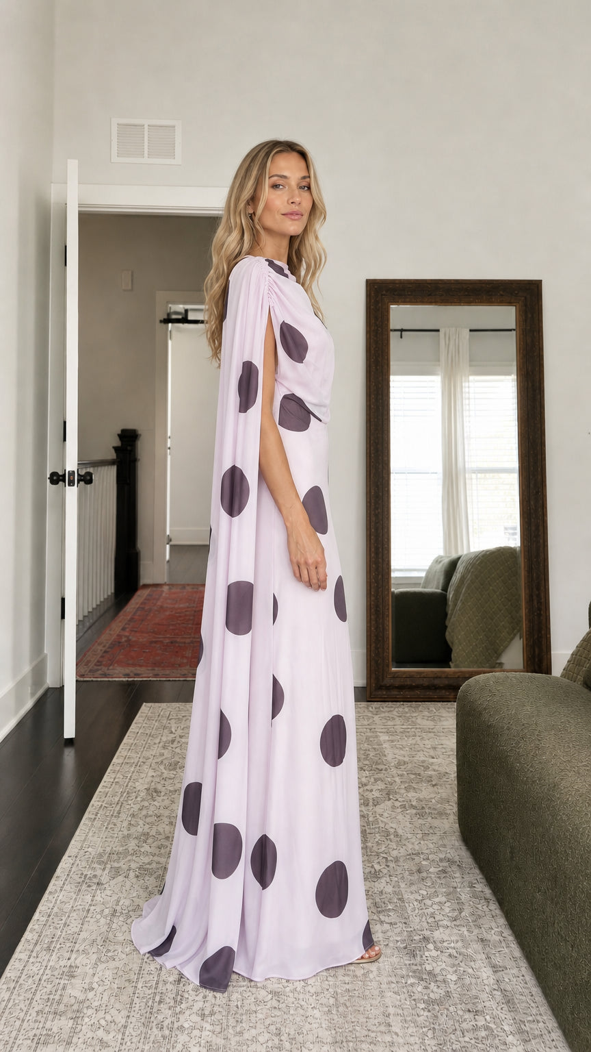 Side profile of model in lavender polka dot cape maxi dress