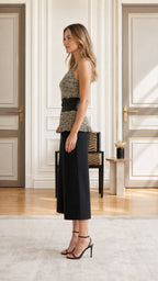 Side profile view of model in olive knit peplum top