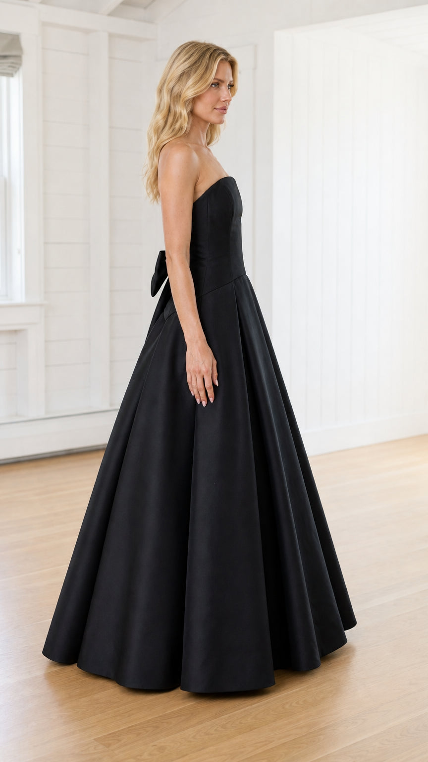 Side profile view of model in black strapless evening gown