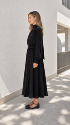 Model wearing black midi dress from the side profile
