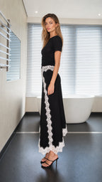 Model wearing black two-piece set, side view