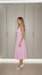 Side profile of model in pink gingham midi dress