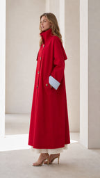 Side profile of woman in a red maxi trench coat