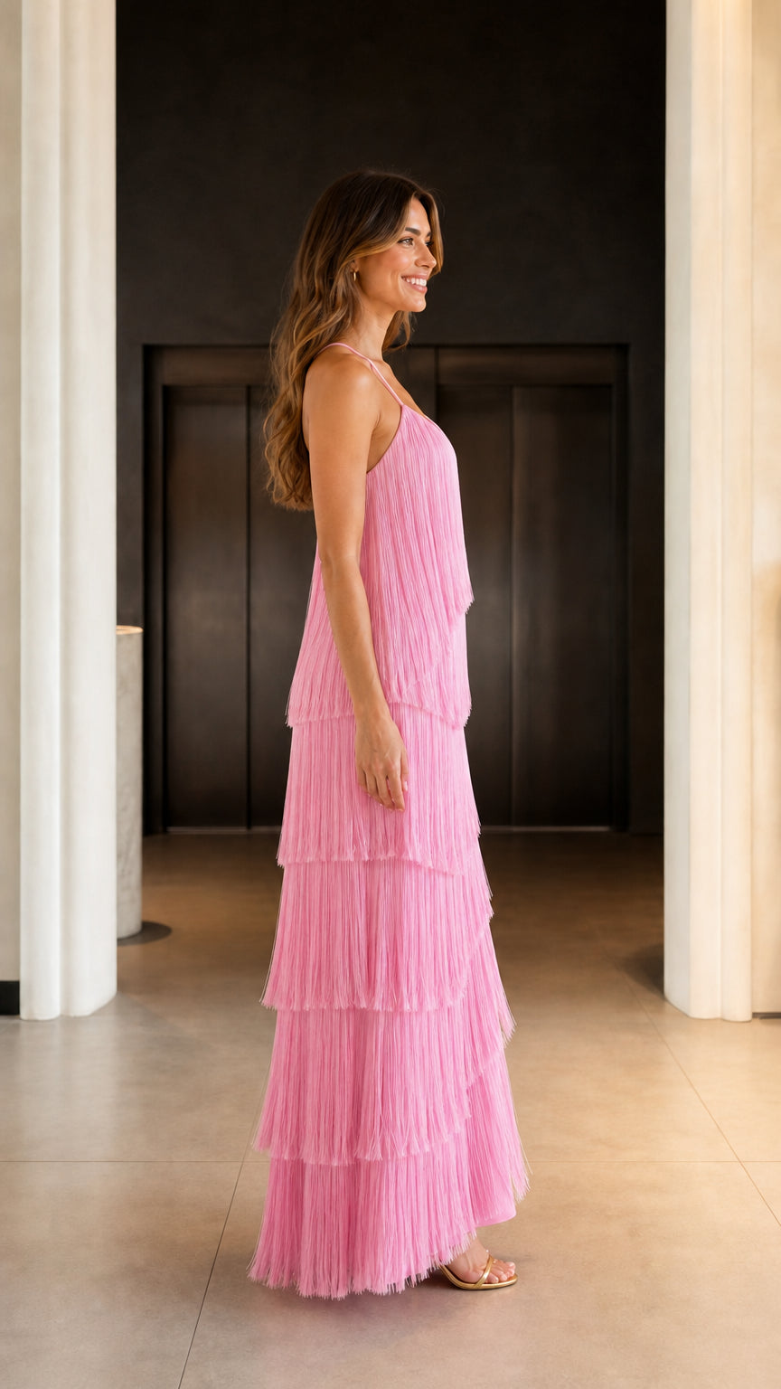 Model wearing pink fringe maxi dress from the side profile