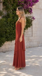 Side profile view of woman in Rust Red maxi dress