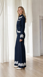 Side profile view of dark denim jumpsuit with wide leg