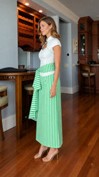 Model wearing white and green striped dress, side profile view