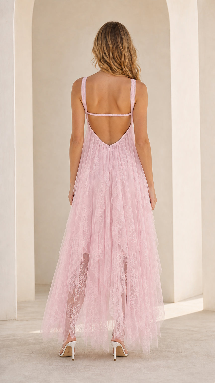 Model wearing pink strapless tulle maxi dress back view showing open back