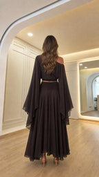 Back view of woman showcasing the draped back design of the dark brown outfit