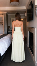 Back view of woman wearing light yellow ruffled maxi dress
