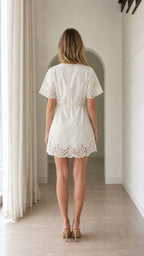 Model wearing white lace trim wrap mini dress back view