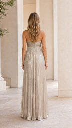 Back view of model wearing gold metallic pleated strapless maxi dress