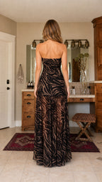 Back view of model in brown zebra print strapless maxi dress