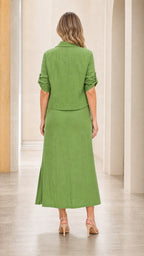 Back view of woman wearing green shirt and maxi skirt