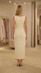 Back view of woman wearing cream sleeveless midi dress