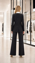 Back view of woman wearing black suit with wide leg trousers