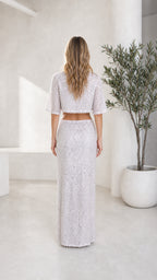 Back view of model in silver sequin crop top and maxi skirt