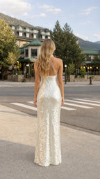 Back view of woman showing open back and straps on white sequin gown