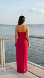 Back view of woman wearing fuchsia strapless cowl neck maxi dress