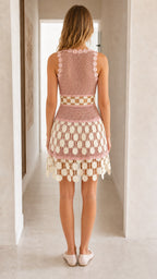 Back view of woman wearing pink crochet mini dress
