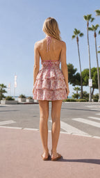 Back view of model wearing pink floral halter mini dress