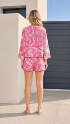 Model wearing pink abstract print set from the back