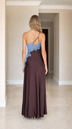 Back view of woman wearing brown one-shoulder satin maxi dress showing strap details
