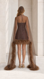 Back view showing long sheer cape and feather hem