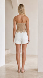 Back view of woman showing back details of beige crochet lace corset top