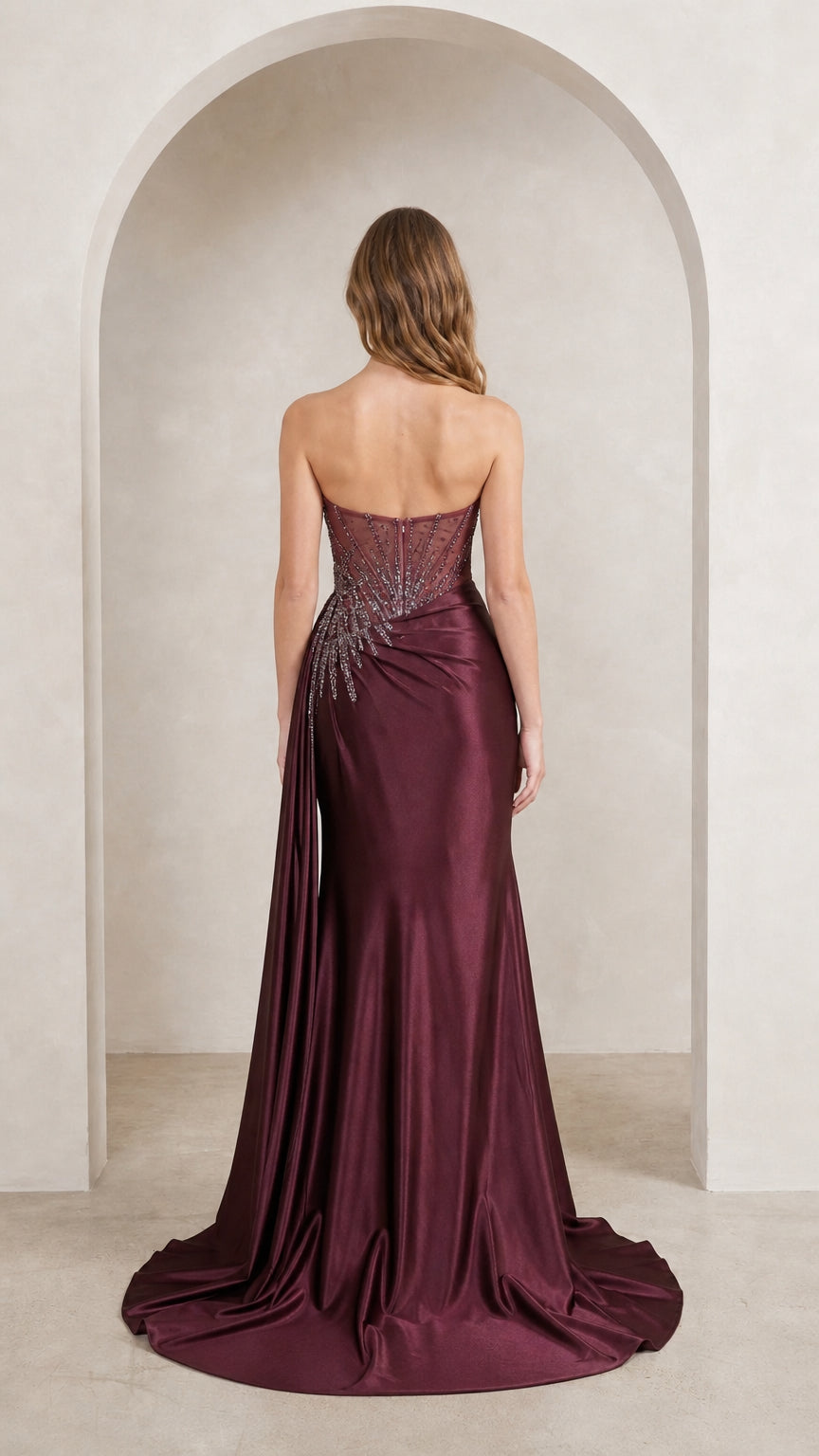 Model wearing burgundy evening gown back view with train