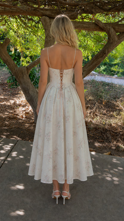 Back view of woman wearing white floral dress with lace-up back detail
