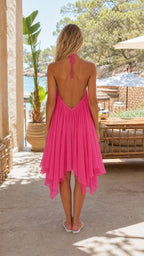 Back view of the pink halter dress featuring an open back design