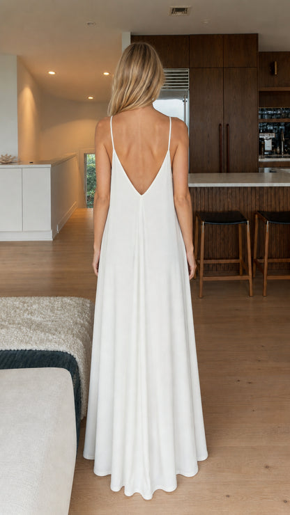 Model wearing white maxi dress, back view showing V-cut