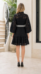 Back view of black lace mini dress showing bishop sleeves