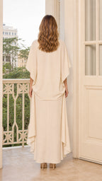 Back view of model showing fluid draping in beige dress