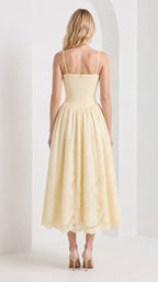 Back view of model wearing yellow embroidered midi dress