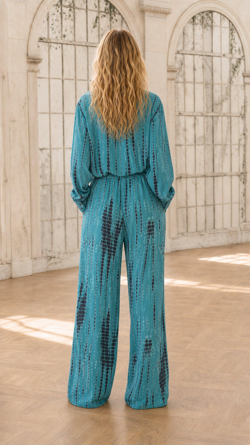 Back view of model in teal tie-dye jumpsuit