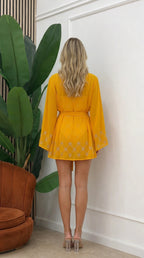 Back view of model wearing yellow three-piece resort set