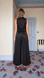 Back view of model wearing black satin jumpsuit
