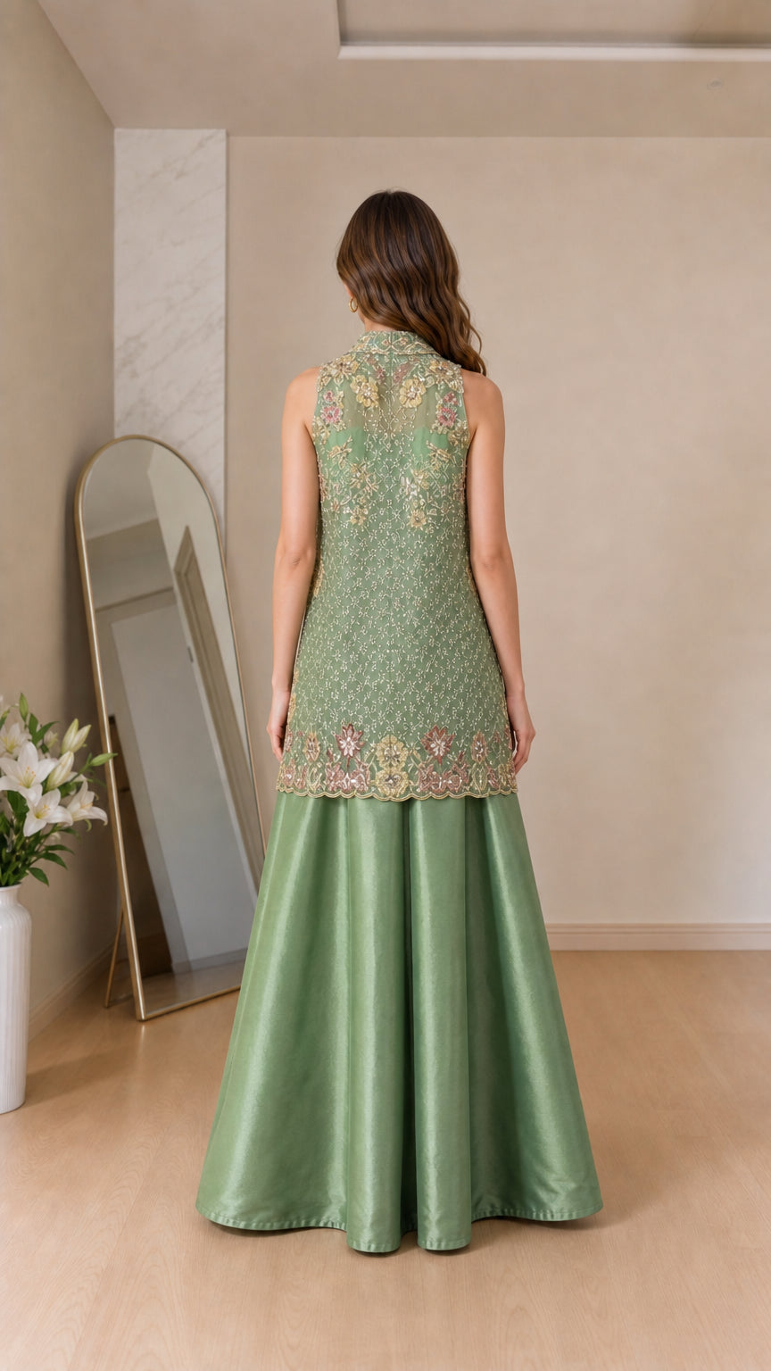 Back view of model showcasing sage green embroidered vest and flowing pants