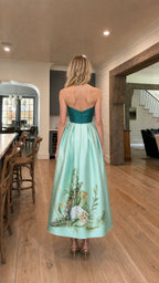 Back view of model in teal and mint strapless evening gown