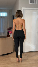 Model wearing gold metallic halter top back view with open back chain detail