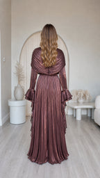Back view of model in metallic brown pleated maxi dress with ruffle details