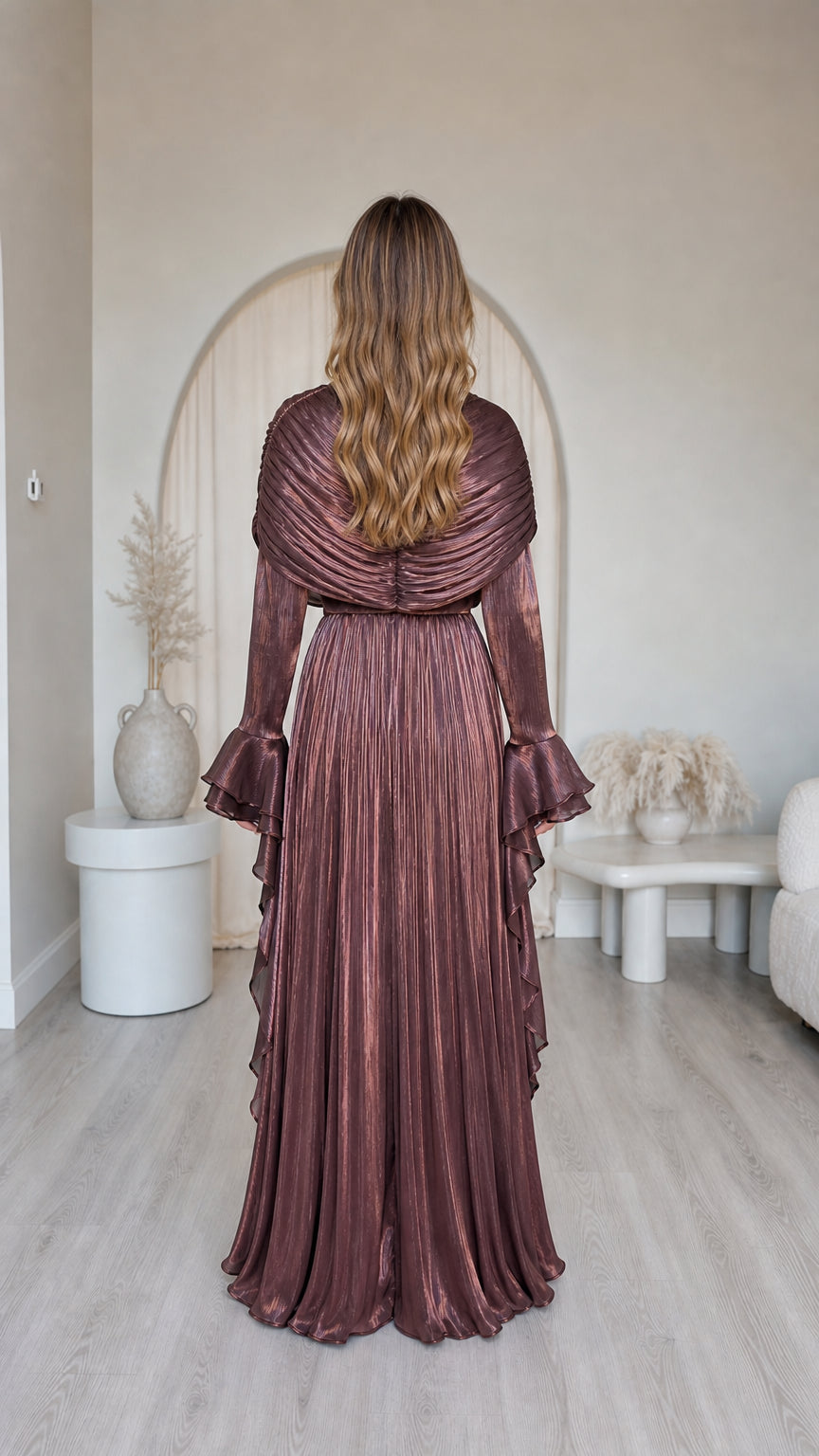 Back view of model in metallic brown pleated maxi dress with ruffle details