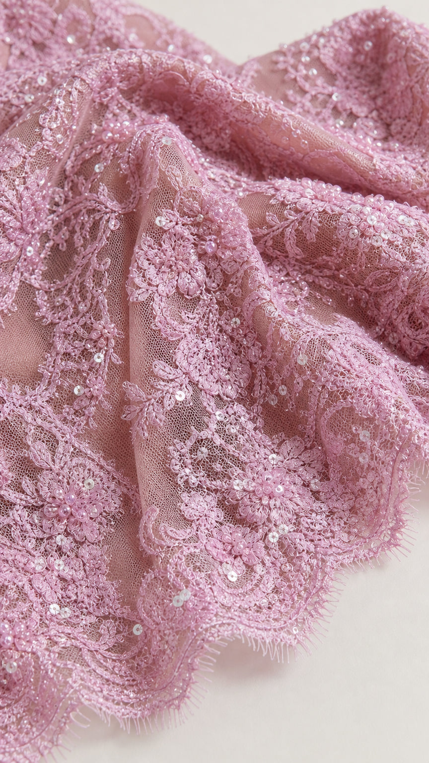 Close-up of pink textured floral lace fabric with subtle embellishments