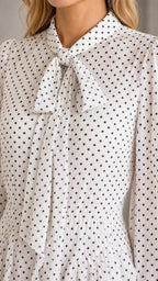 Close-up detail of the tie neck collar and polka dot pattern