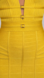 Close-up of bodice detailing, neckline, and gold buckles on yellow dress
