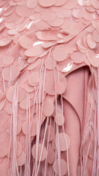 Close-up detail of paillettes and tassel fringe on pink dress