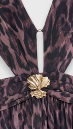 Close-up detail of the plunging neckline, waist cutout, and gold shell hardware