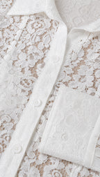 Close-up detail of white floral lace fabric and button placket